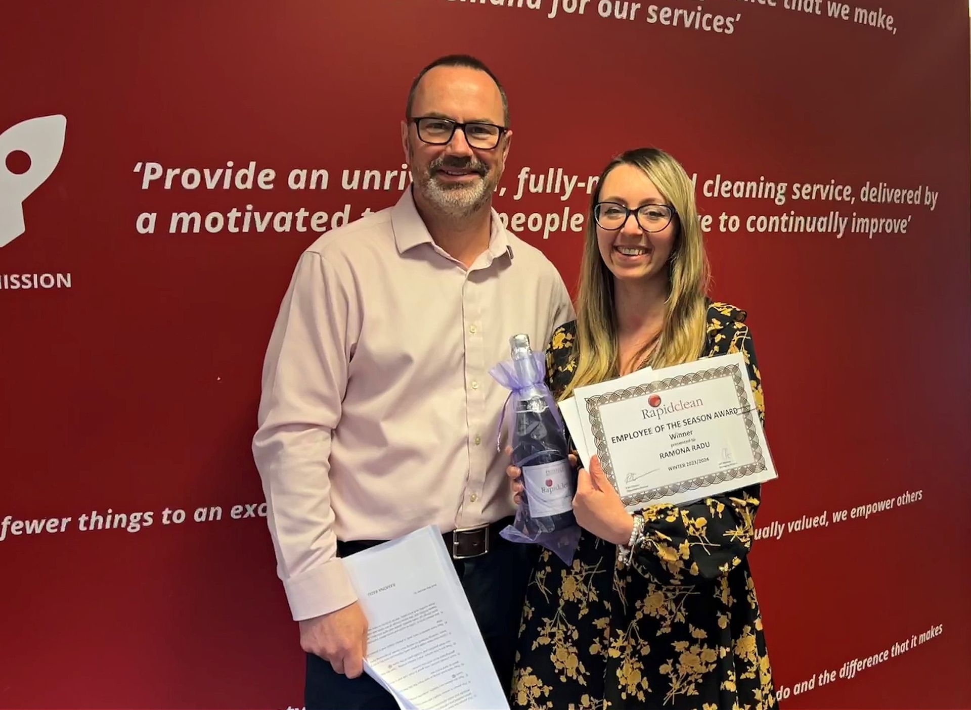 A man and a woman are standing next to each other holding a certificate.