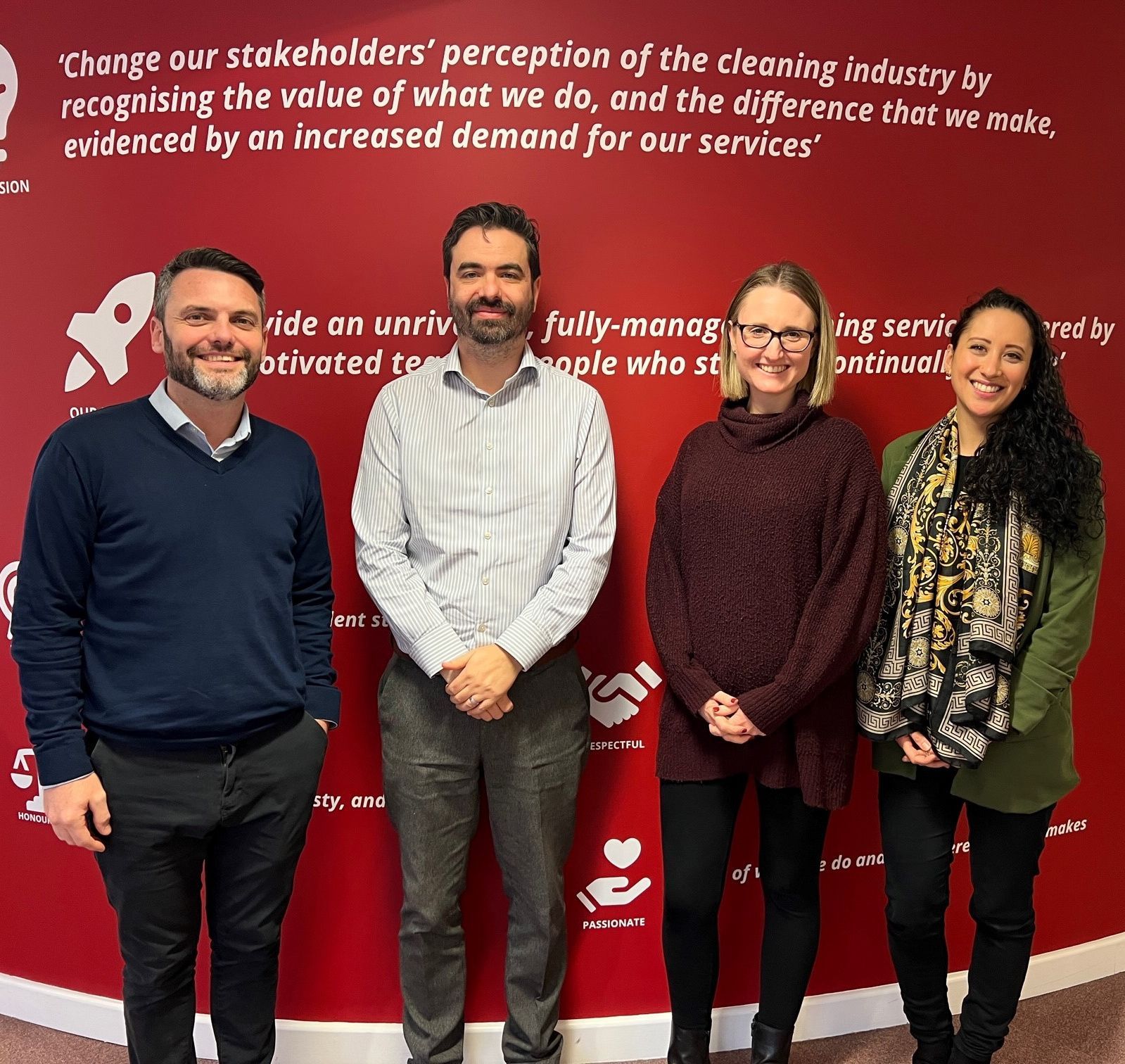 A group of people standing in front of a sign that says change our stakeholders perception of the cleaning industry