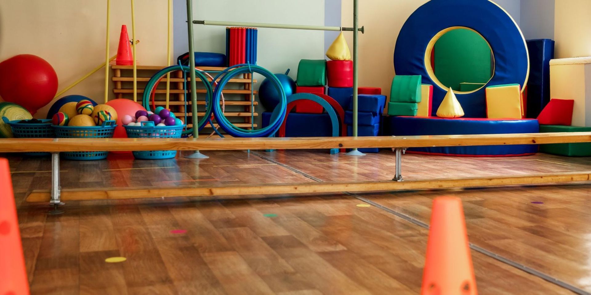 A gym filled with lots of colorful toys and cones.
