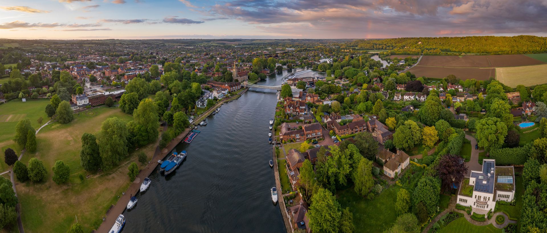 An aerial view of a river surrounded by trees and houses.
