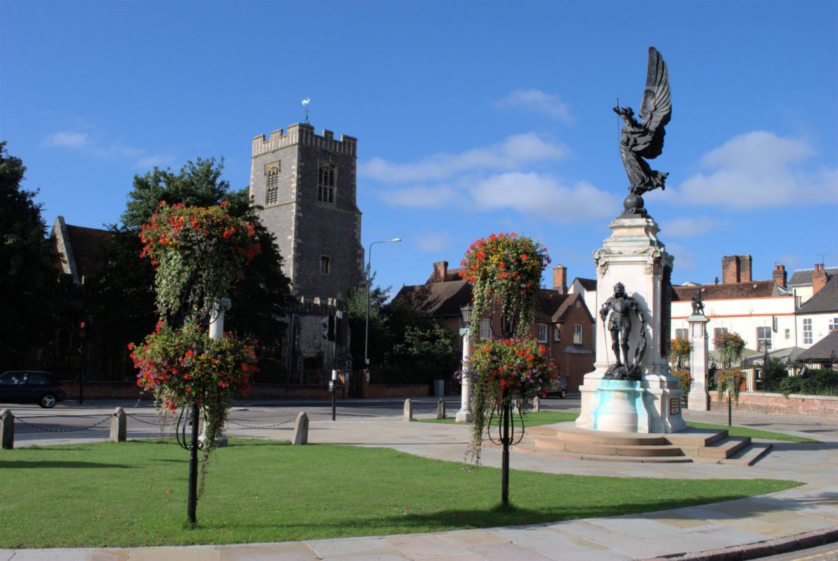 A statue in a park with a church in the background