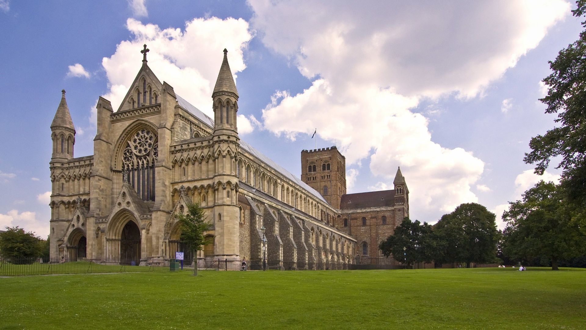 A large building with a blue sky and clouds in the background