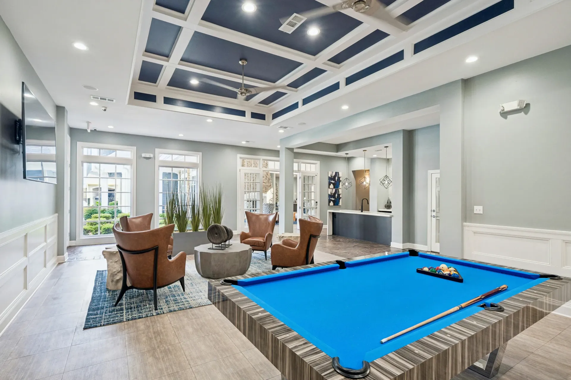 Stylish resident lounge with a bright blue pool table, comfortable seating, and a modern bar area.