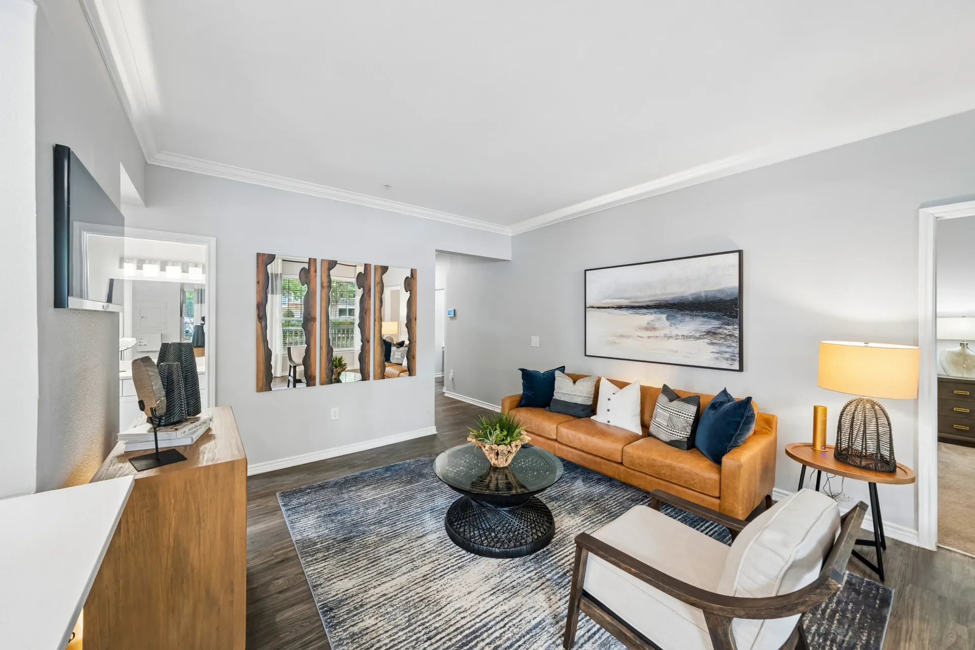 A beautifully staged living room with a tan leather sofa, armchair, and a modern coffee table.
