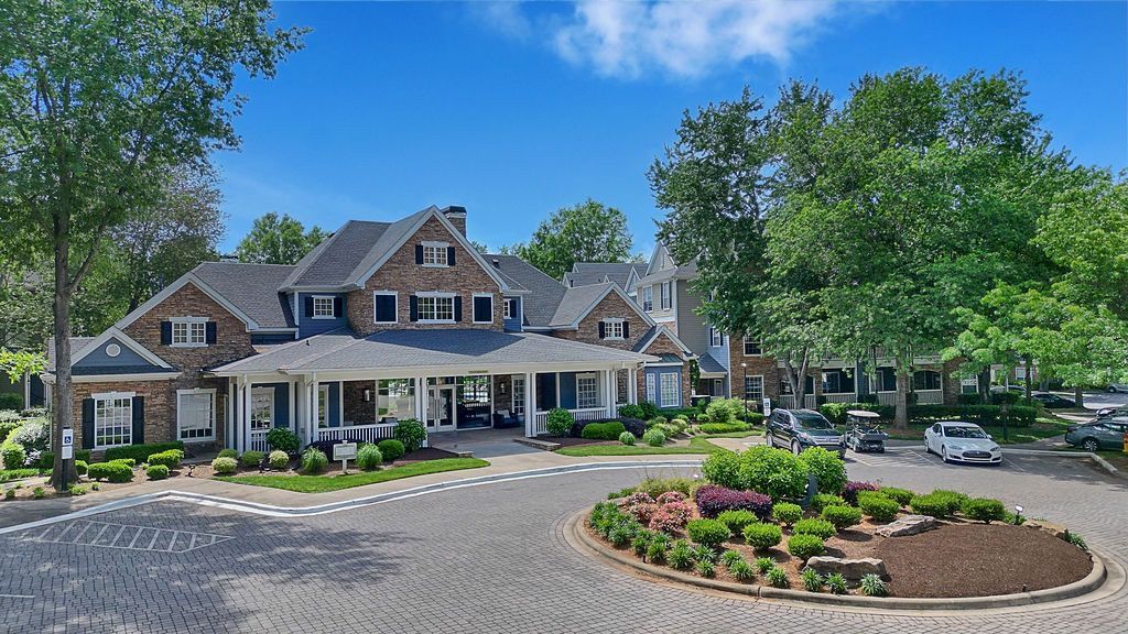 Exterior view of a multifamily community building with landscaped entrance and circular driveway at The Piedmont.