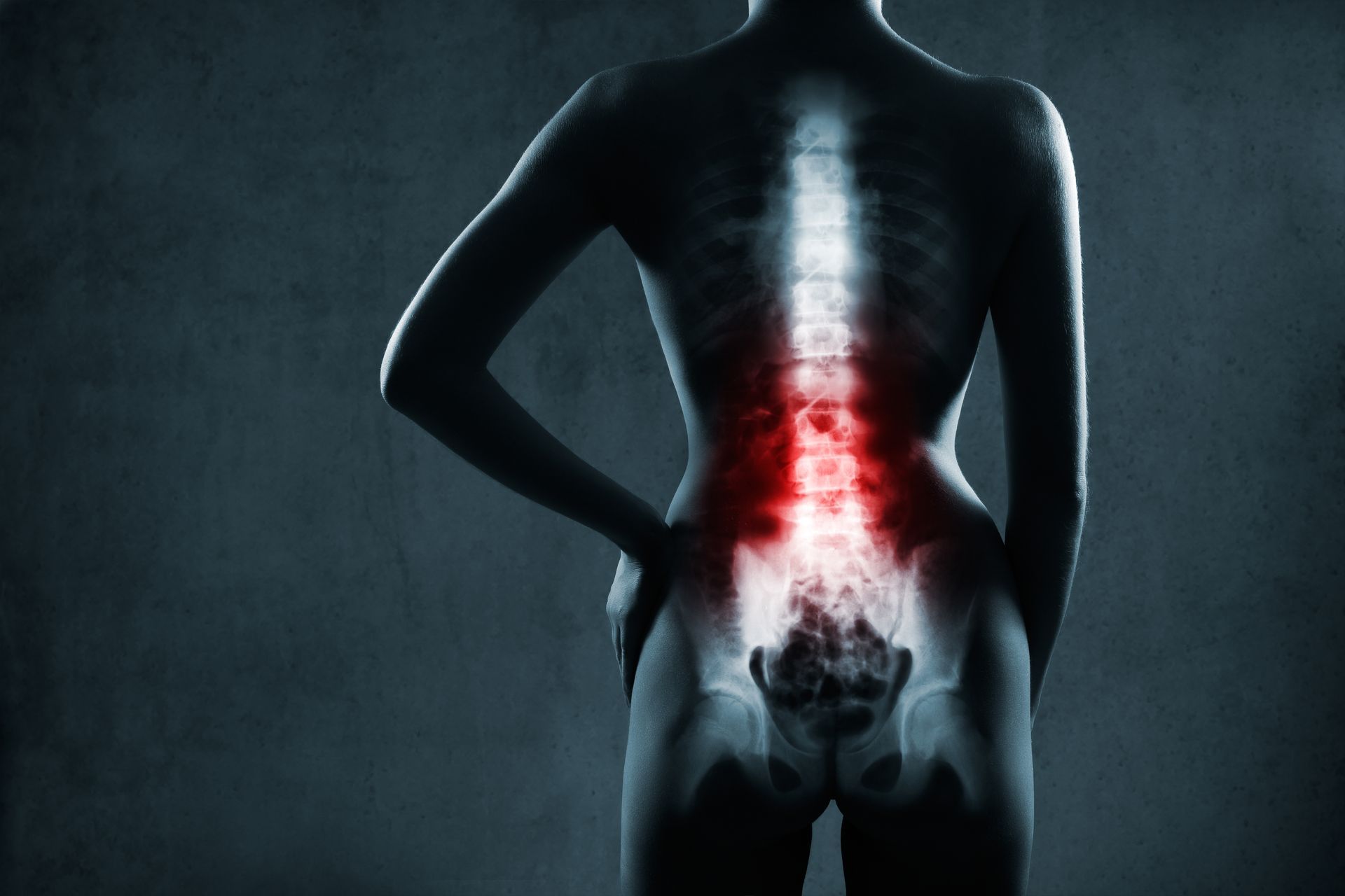 A silhouette of a human torso with the spine highlighted in glowing white and red, indicating pain in the lower back.