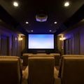 Home theater with recliner seats, dim ceiling lights, and a large projection screen.
