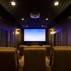 Home theater with recliner seats, dim ceiling lights, and a large projection screen.