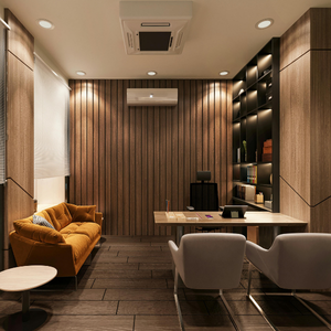 Warm modern lounge with tan sofa, two chairs, wood-paneled walls, shelves, and a desk under recessed lighting