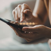 Hand tapping a 5-star rating on a smartphone screen