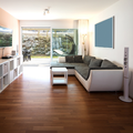 Modern living room with gray sectional sofa, wood floors, large sliding glass door, and TV console