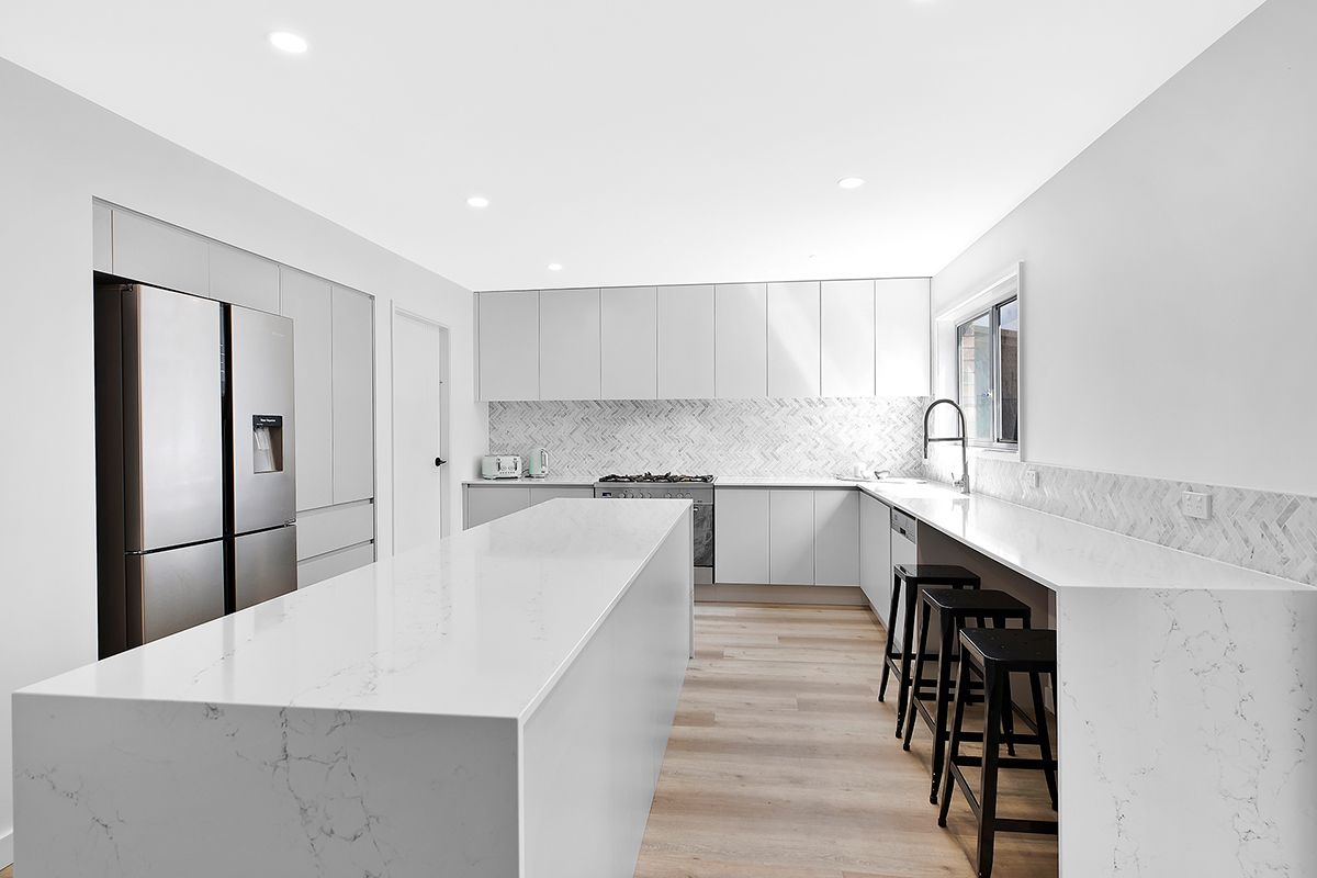 Modern, All-white Kitchen With Island, Countertops, and Wood Flooring — Trim Joinery In Fountaindale, NSW
