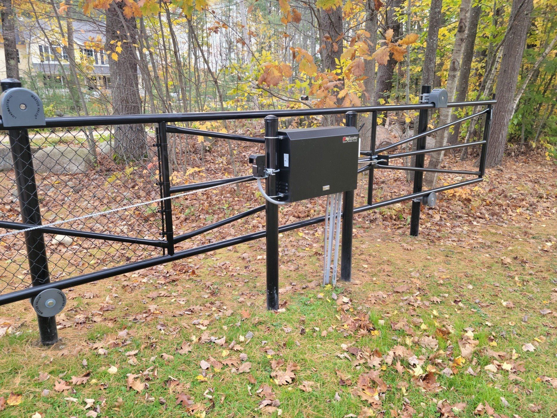 a black mailbox is attached to a chain link fence .