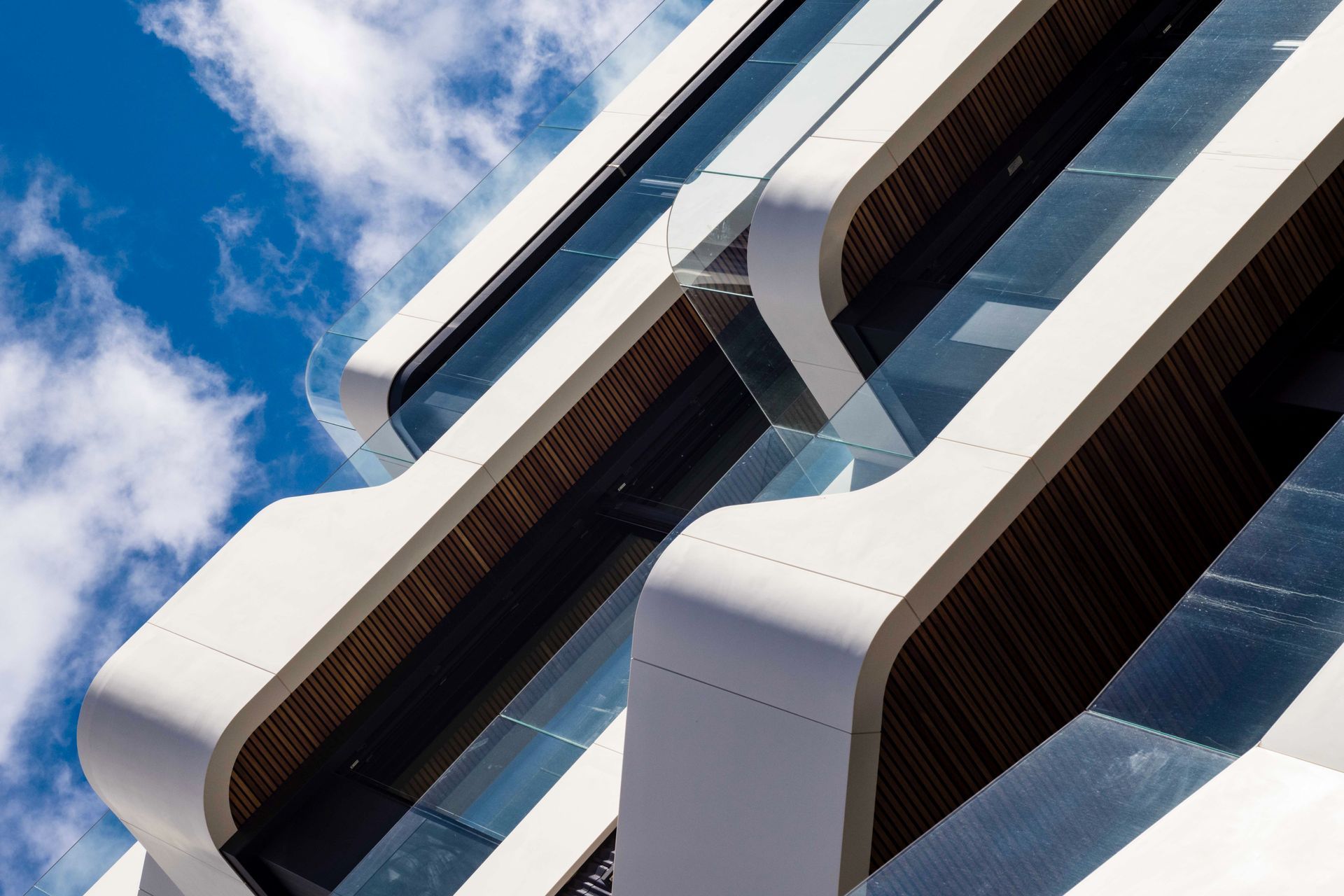 Façana d'edifici modern blanc i blau vista des de baix contra un cel ennuvolat
