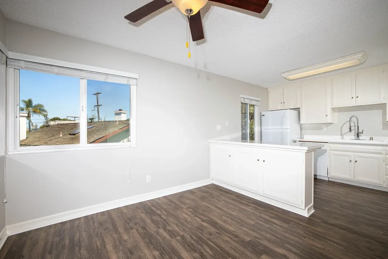 Kitchen and dining area with a large window and ceiling fan