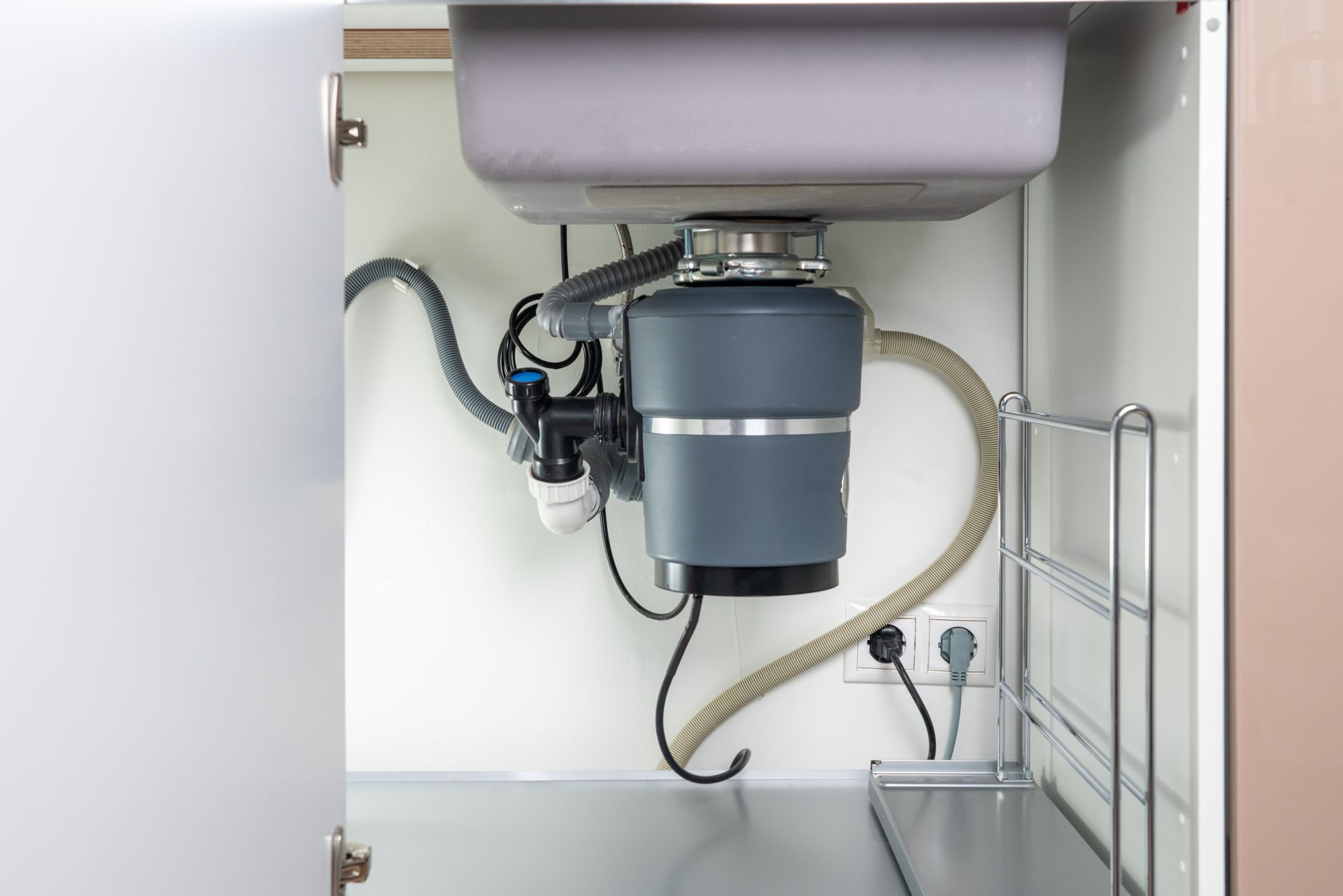A kitchen sink with a garbage disposal underneath it.