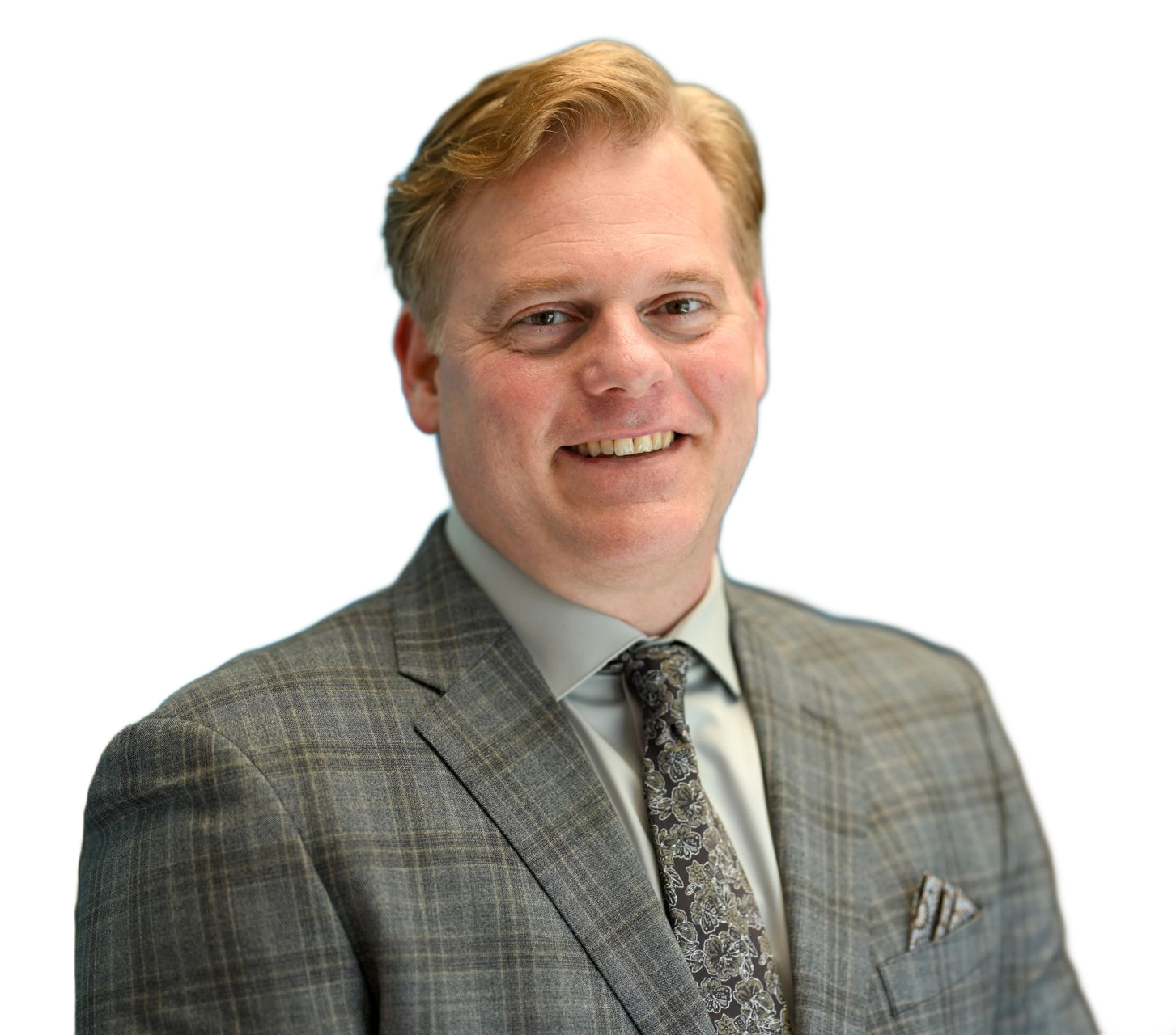 Man in gray suit smiles, facing forward. Light hair, tie, pocket square.