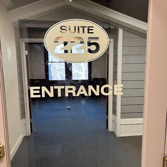Entrance to Suite 225 in a gray hallway, with a large “ENTRANCE” sign on the door.