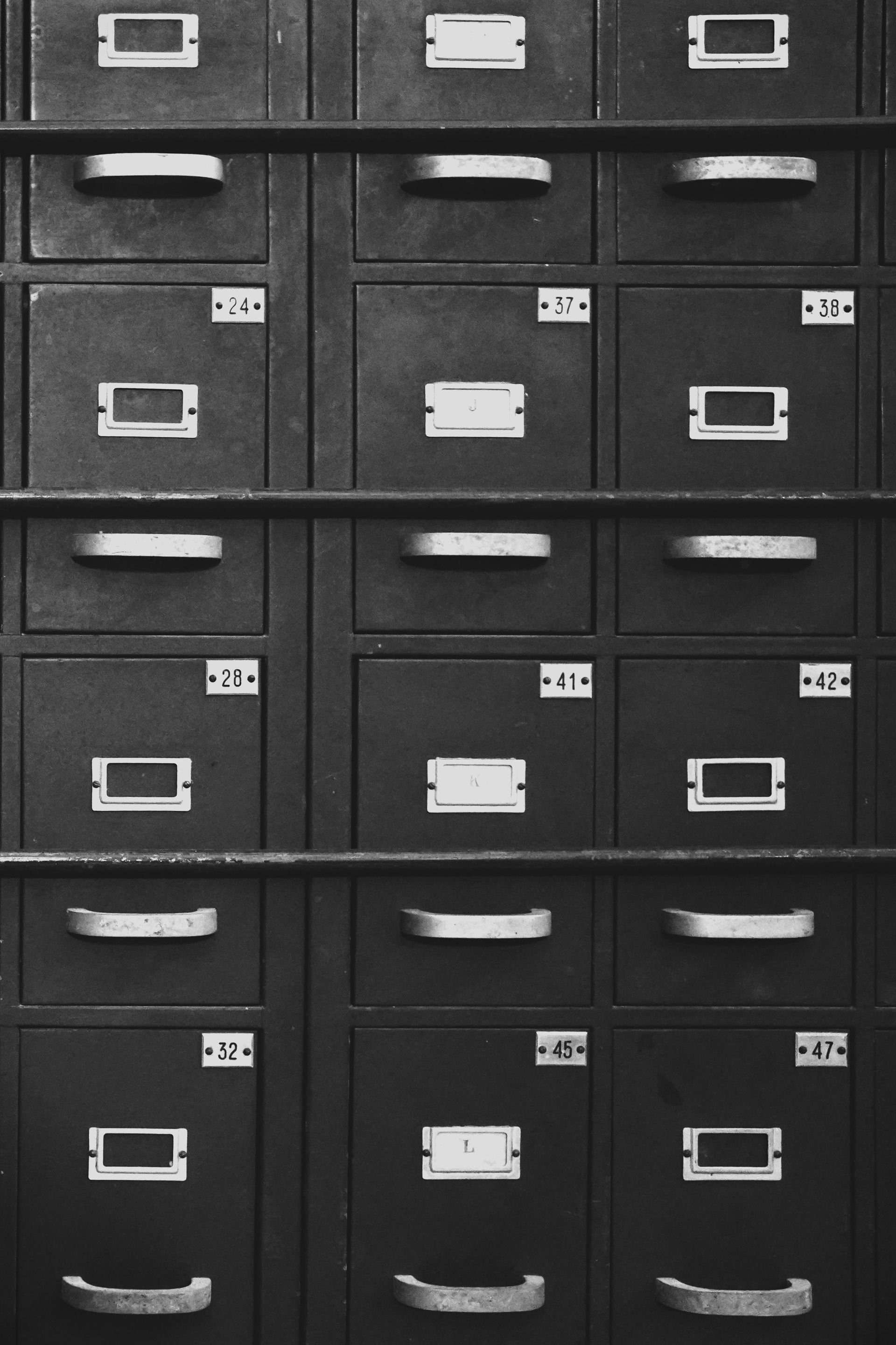 Rows of dark filing cabinets with labeled drawers and metal handles