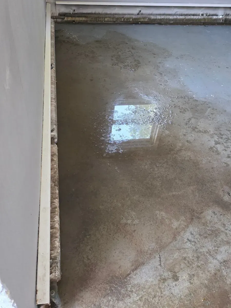 Standing water on a stripped subfloor in a Piscataway, NJ home after water damage