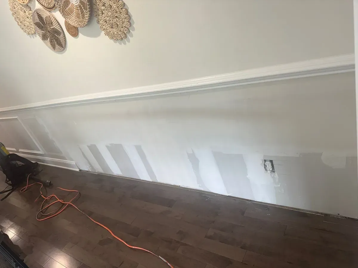 Restored Howell, NJ hallway with white wainscot and dark wood flooring