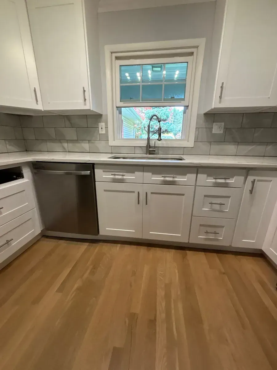 Finished Marlboro, NJ kitchen with white shaker cabinets, stone-look counters and tile backsplash