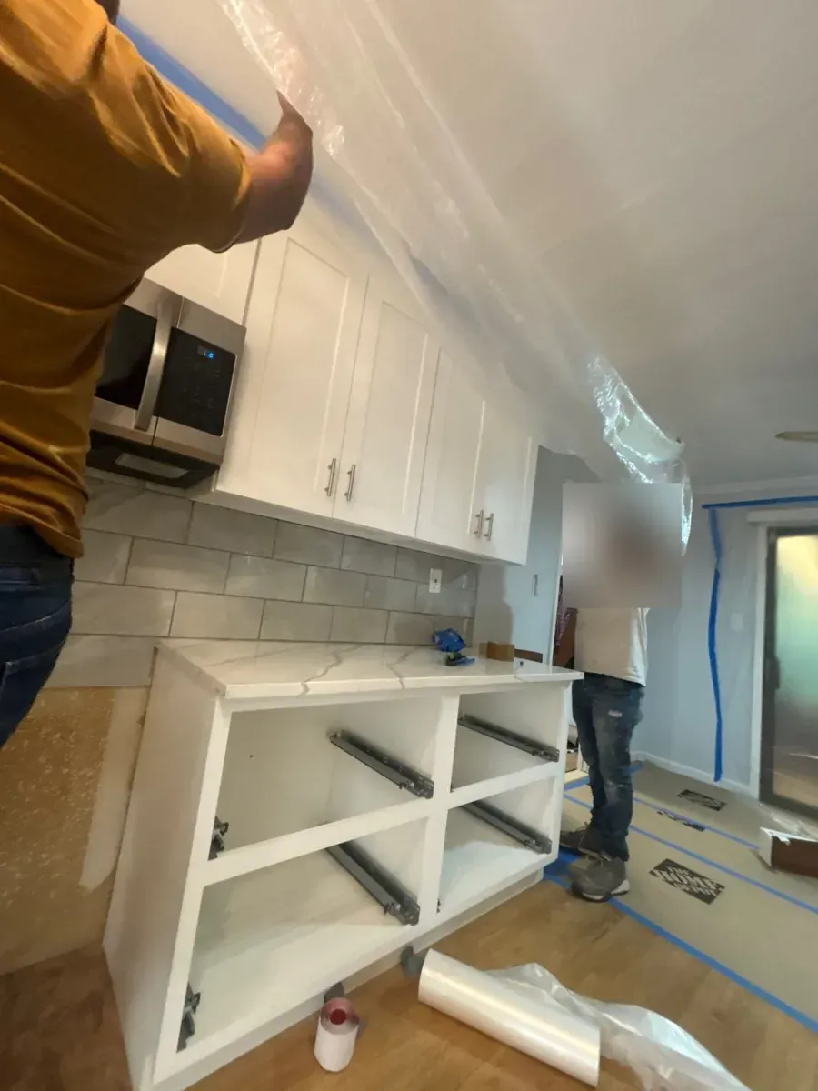 Marlboro, NJ kitchen being rebuilt after water damage, cabinet boxes open and plastic protecting the walls