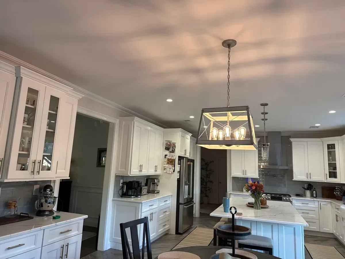 Finished Howell, NJ kitchen with white cabinets, island and a lantern pendant light