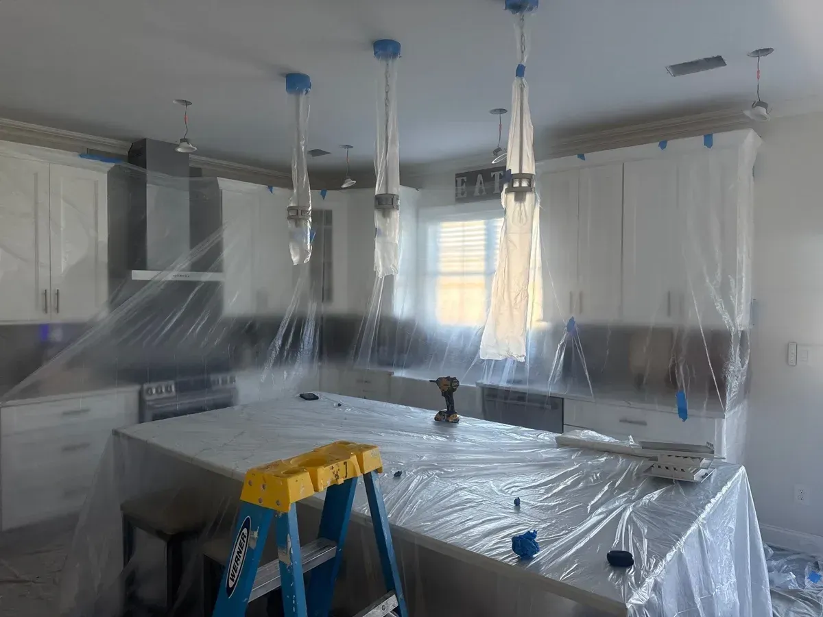 Howell, NJ kitchen wrapped in plastic sheeting with pendant lights bagged during ceiling and wall repairs