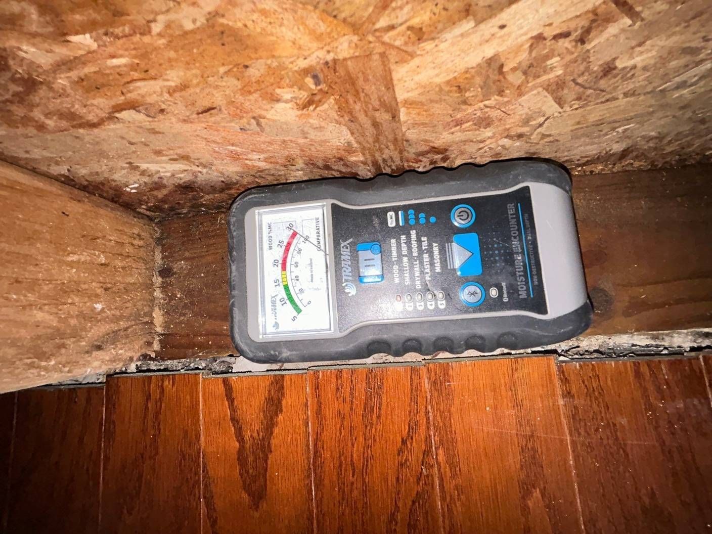 Moisture meter reading on exposed subfloor framing during mold inspection