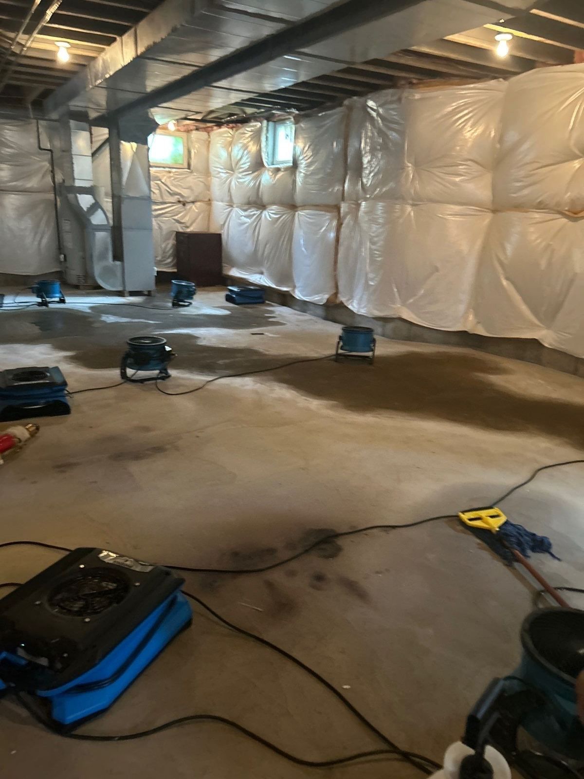 Room under containment with air movers drying the floor after a frozen pipe burst