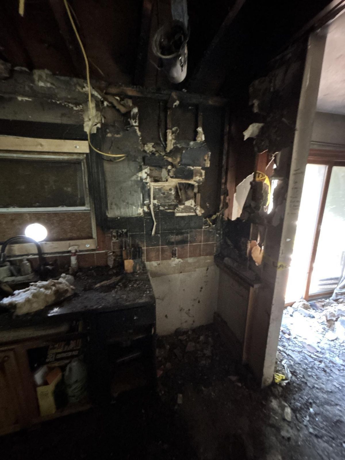 Charred kitchen cabinets and soot-covered counters after a kitchen fire