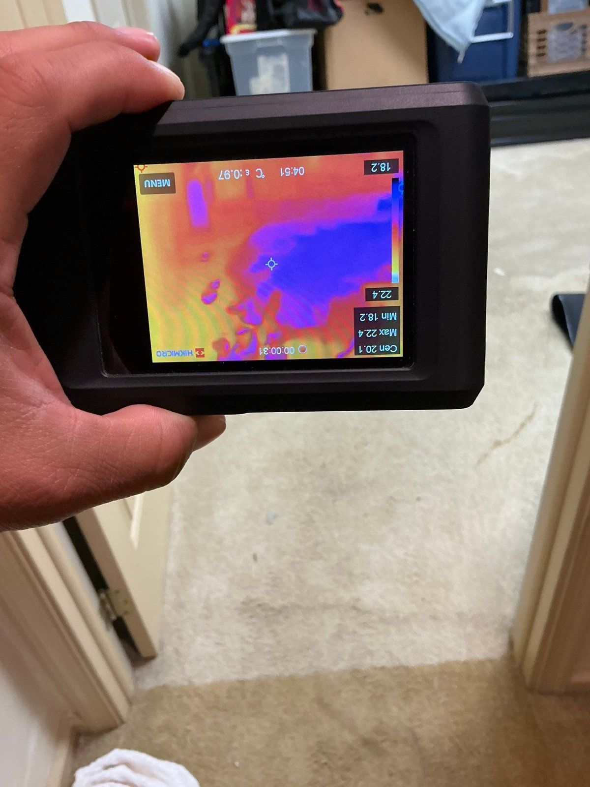 Thermal camera showing a cool wet patch on carpet during water damage drying in NJ
