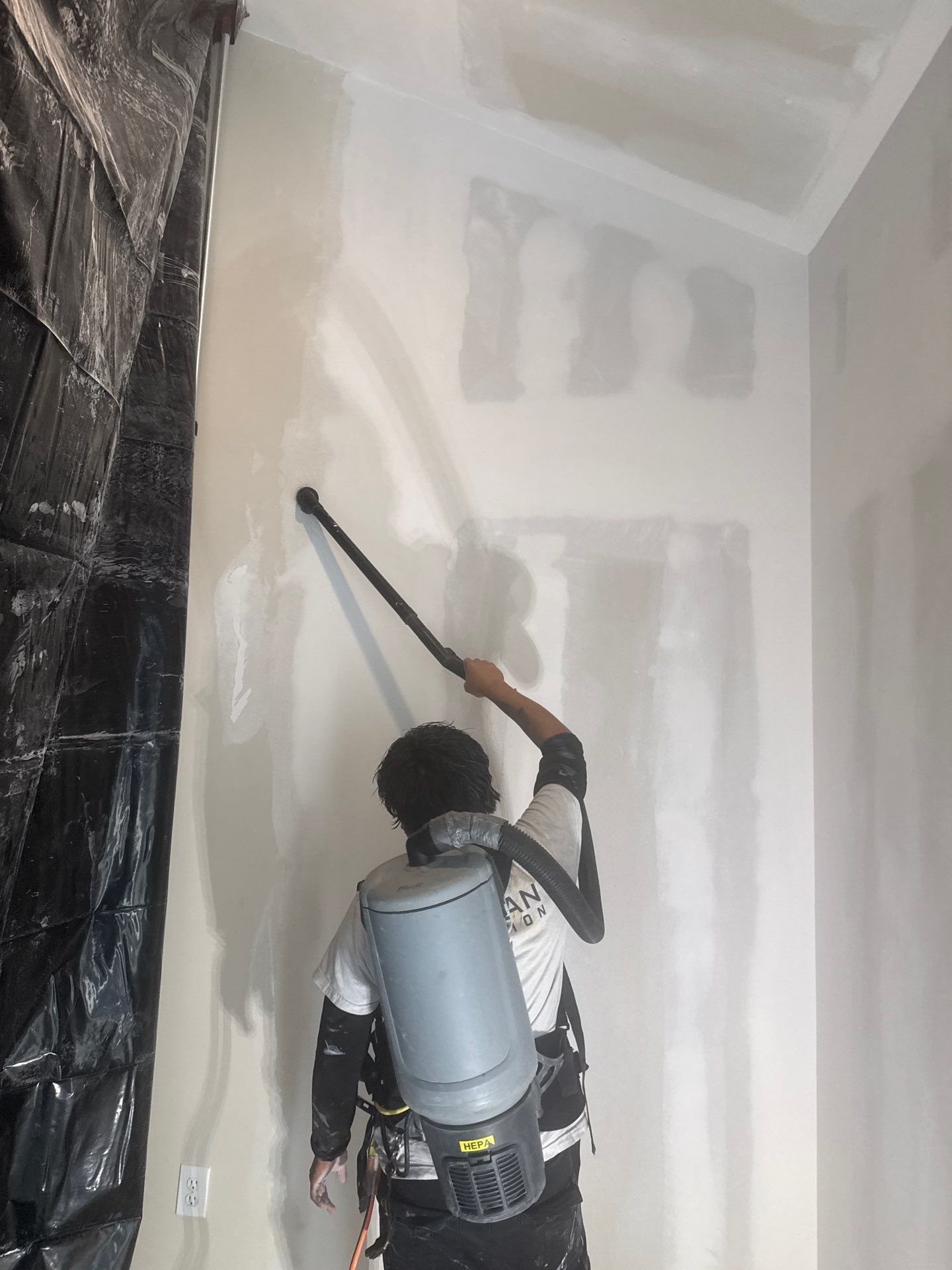 MaxClean Restoration technician using a backpack HEPA vacuum next to plastic containment during mold remediation in New Jersey