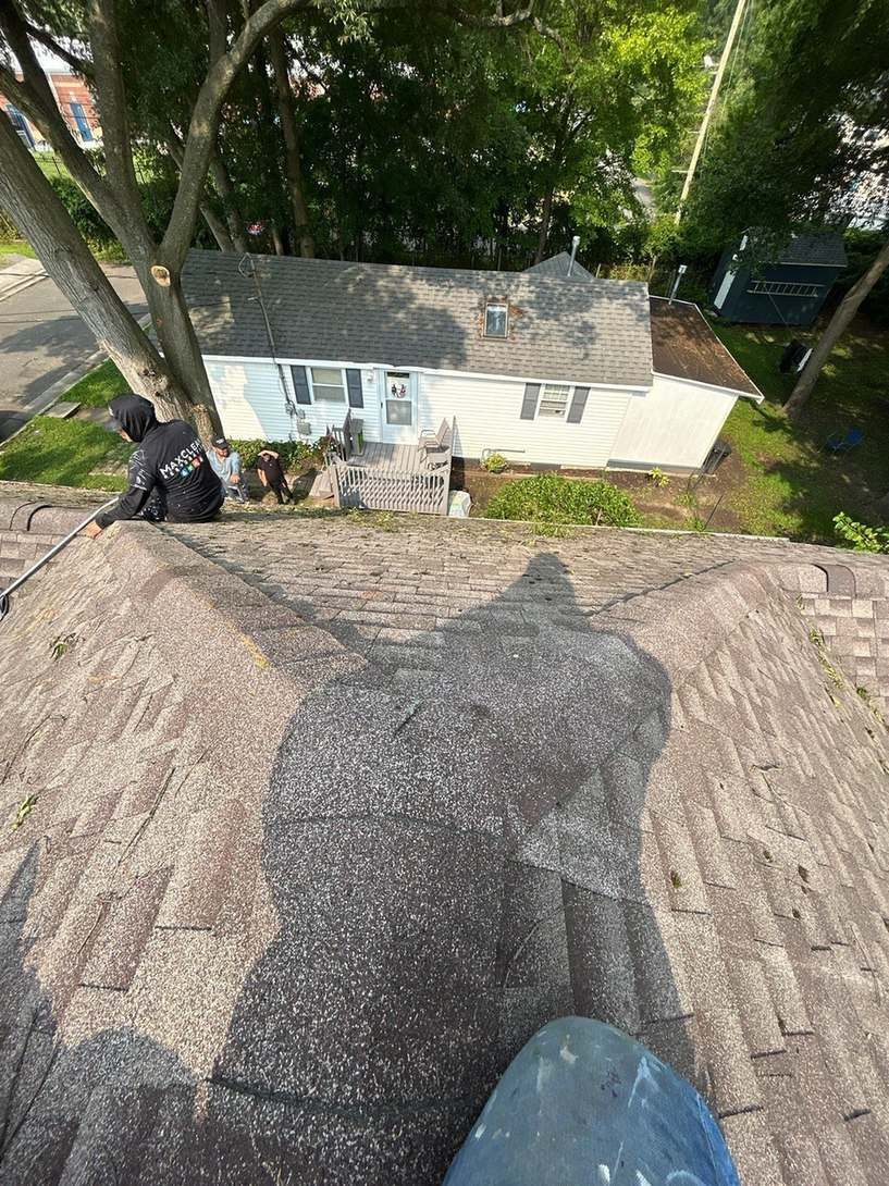 Inspecting worn roof shingles at the source of a roof leak