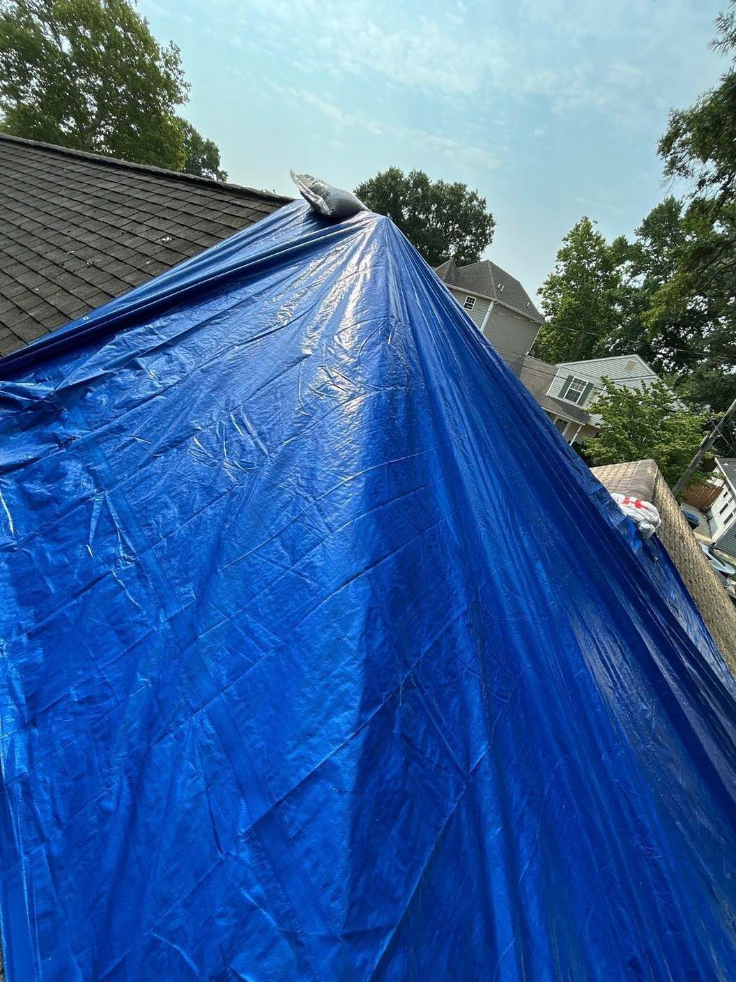 Blue tarp covering a leaking roof to stop water intrusion