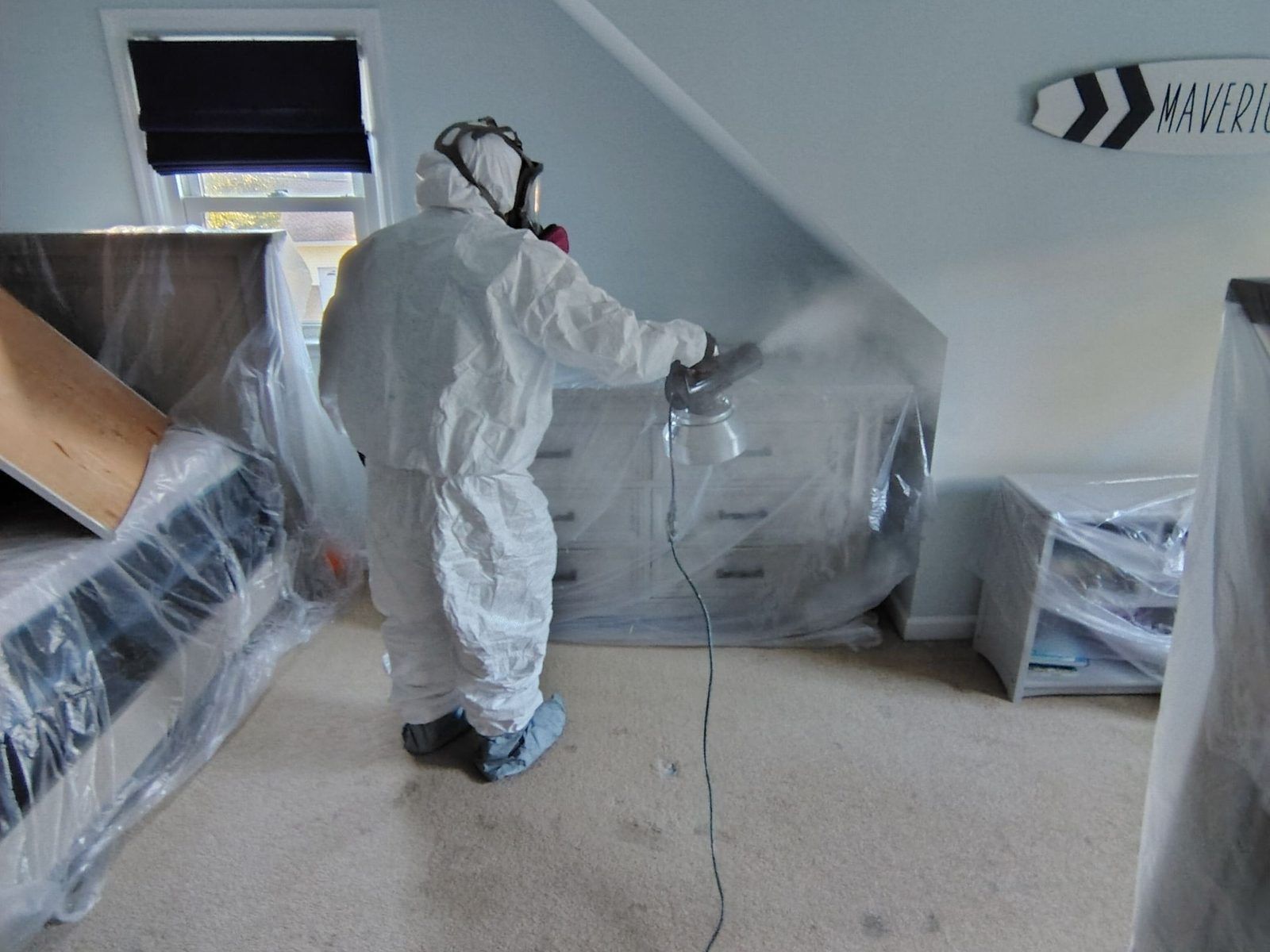 Technician in protective suit fogging a room to remove smoke odor