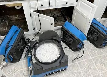 A bunch of fans are sitting on the floor in a kitchen.