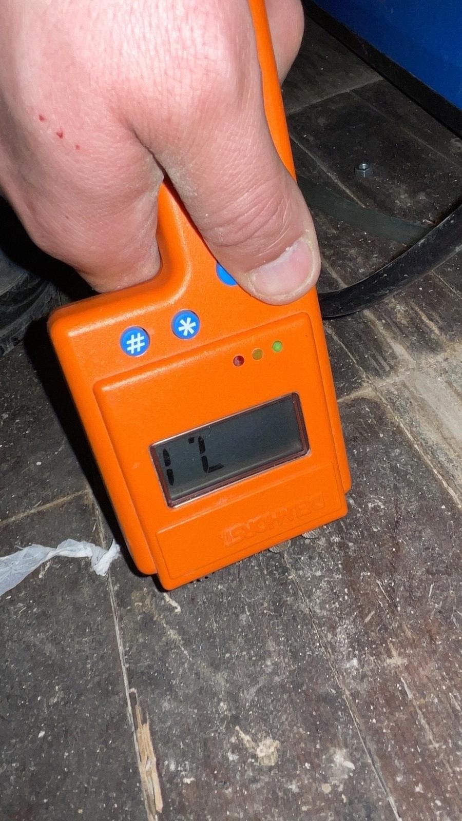 Moisture meter reading taken on a floor to document water damage
