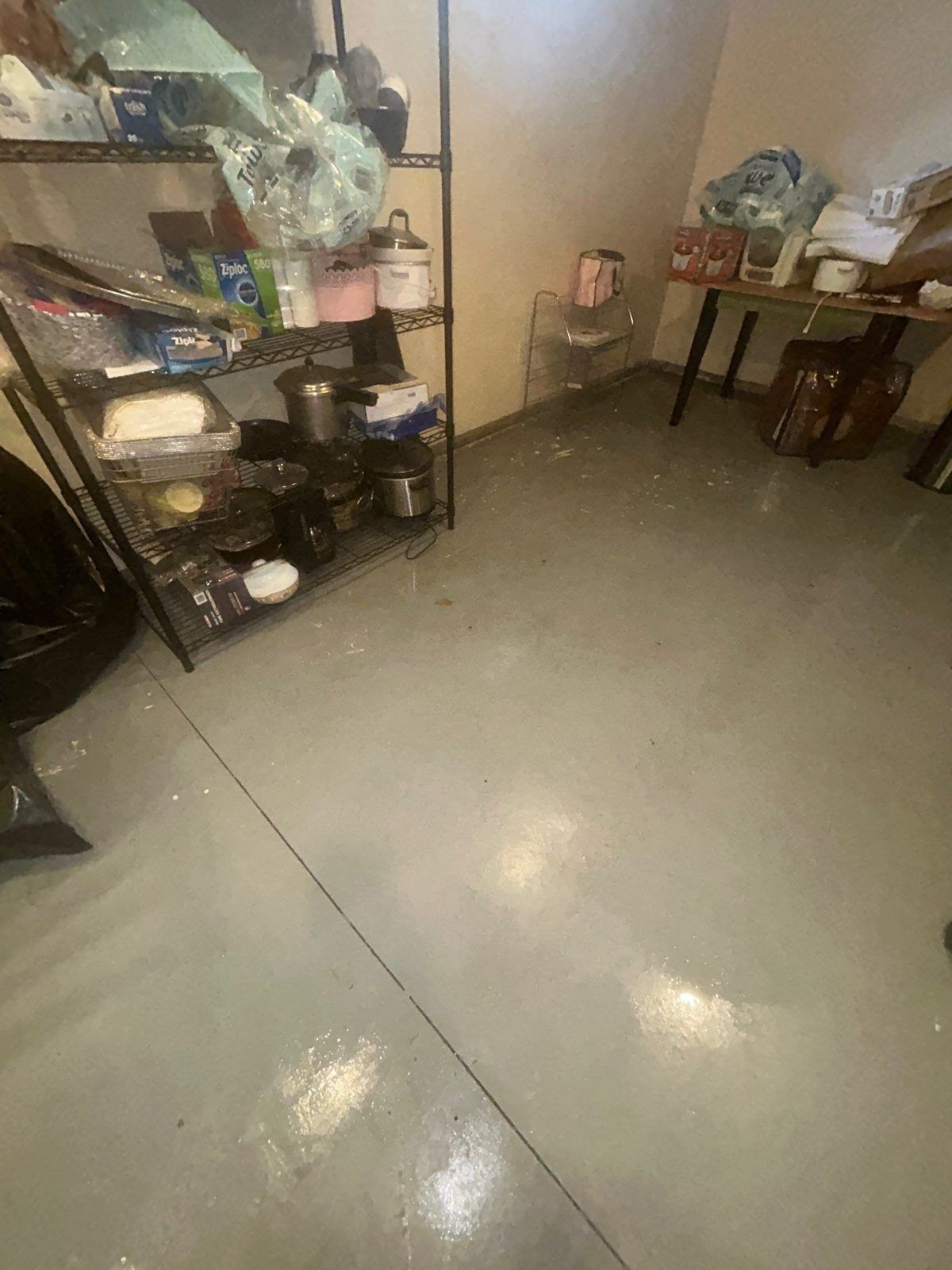 Wet concrete basement slab after a water leak, before drying