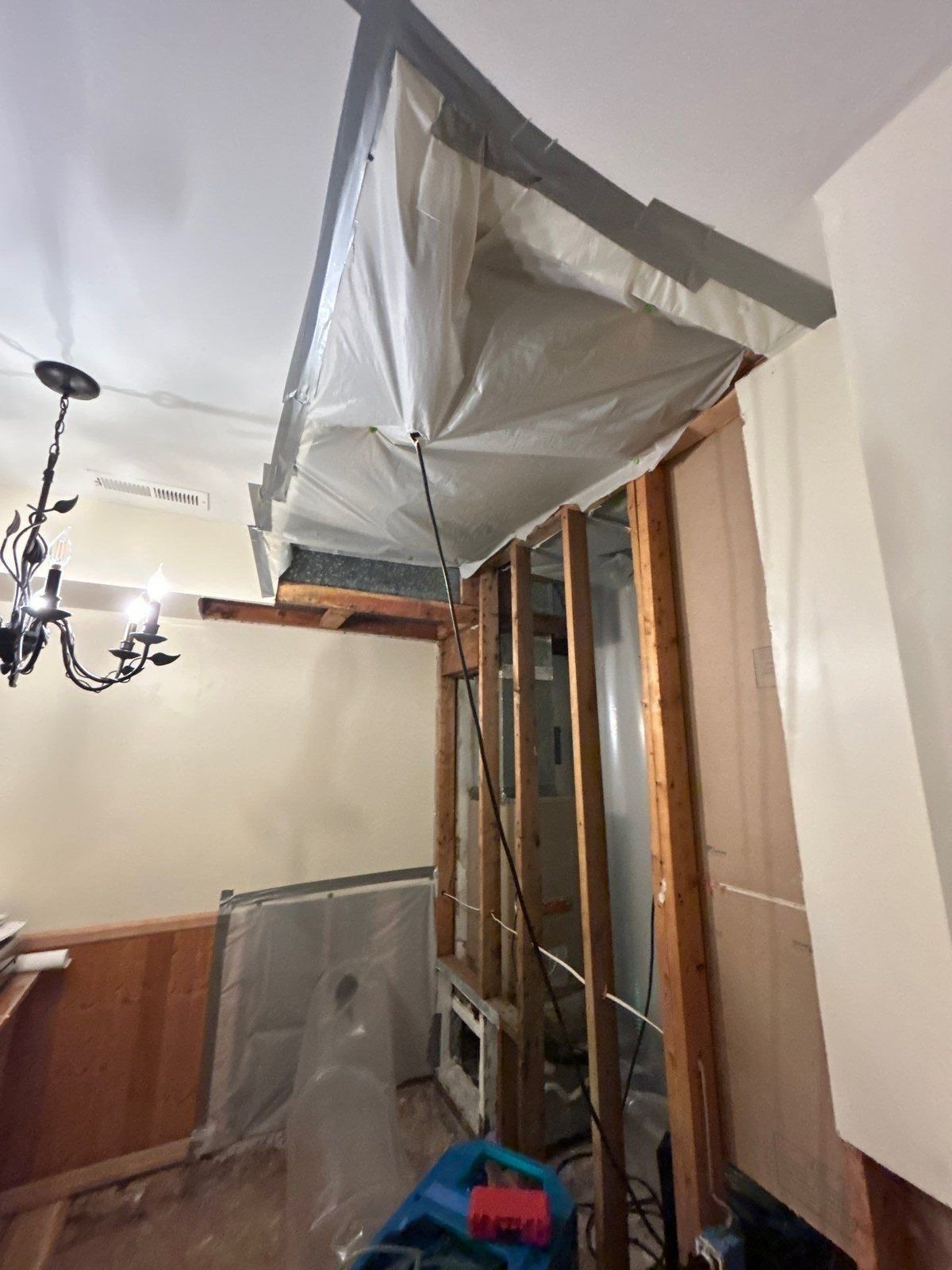 Opened ceiling and wall cavity sealed with plastic containment during structural drying
