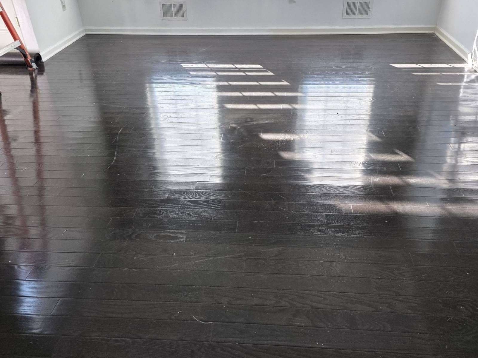 Bright room with newly refinished glossy dark hardwood floors