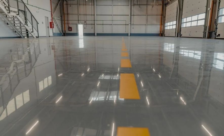 Durable grey industrial epoxy floor with yellow safety markings.