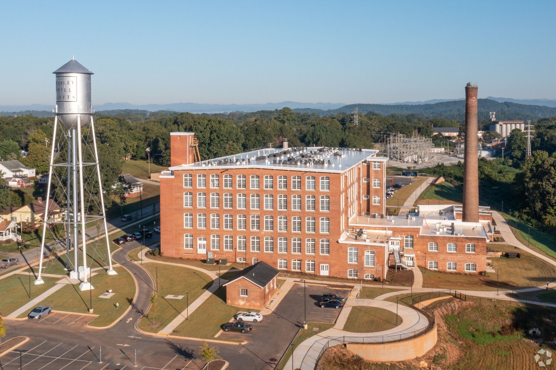 An aerial view of a large brick building with a water tower in front of it.