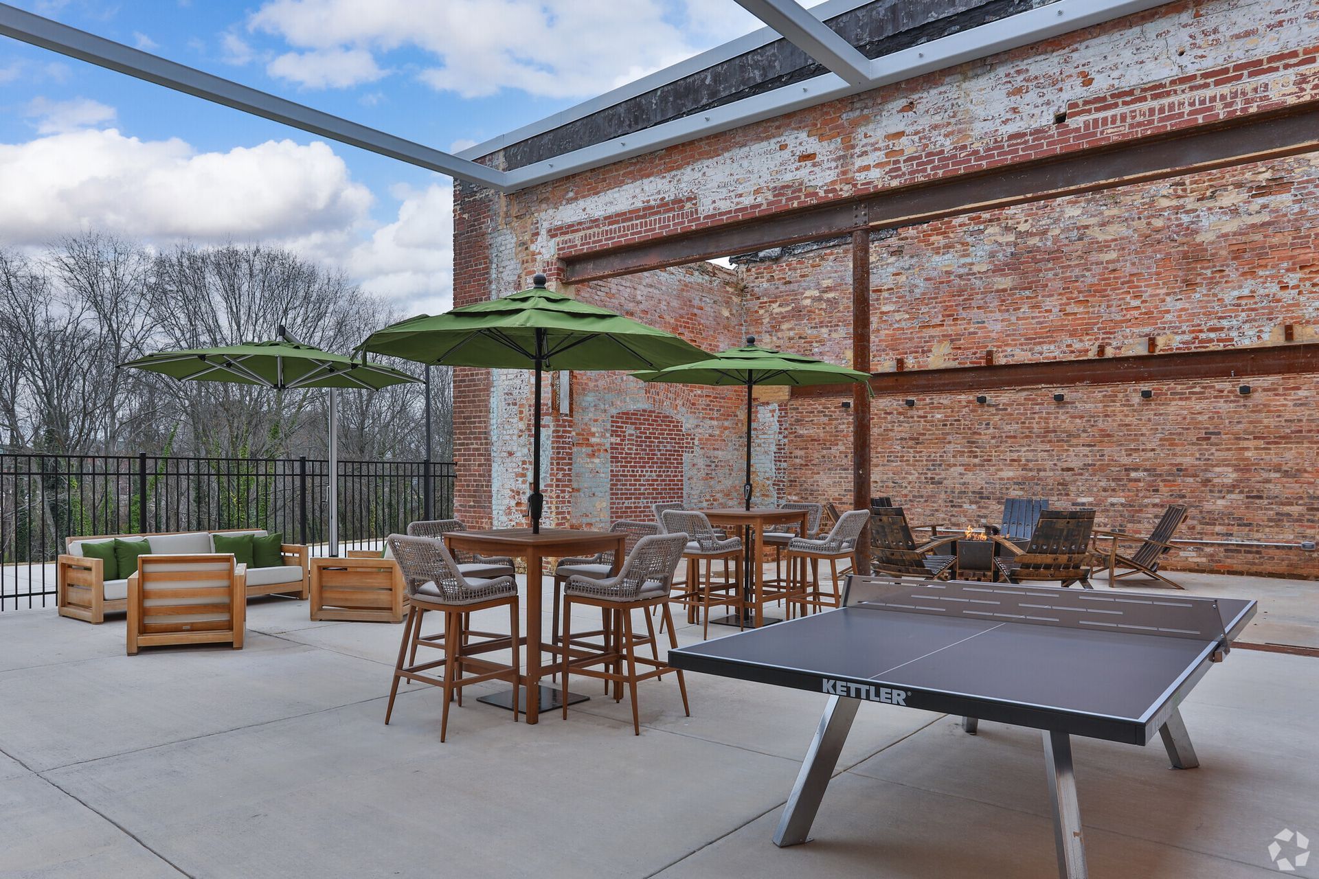 A patio with tables , chairs , umbrellas and a ping pong table.