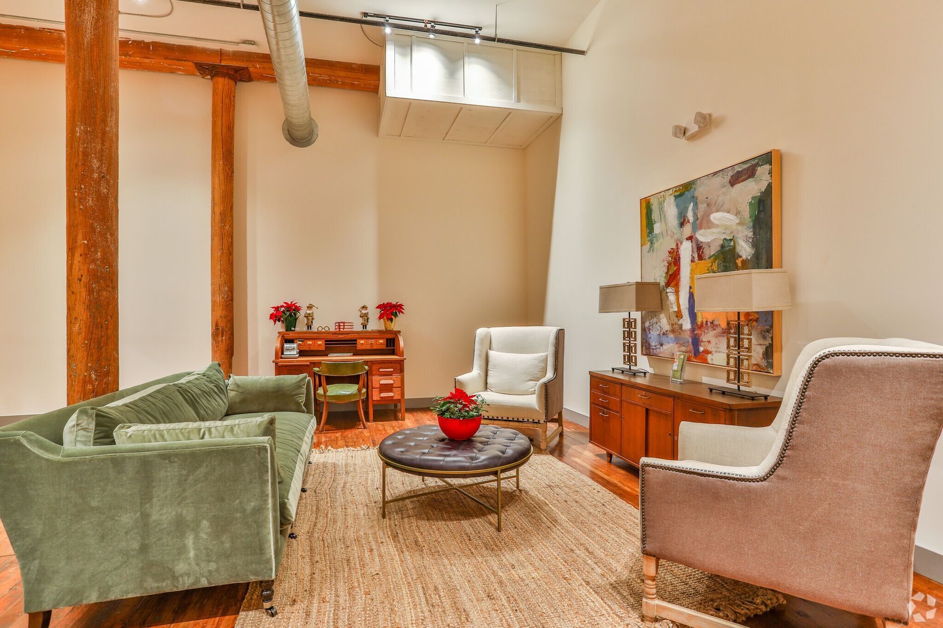 A living room with a green couch and two chairs.