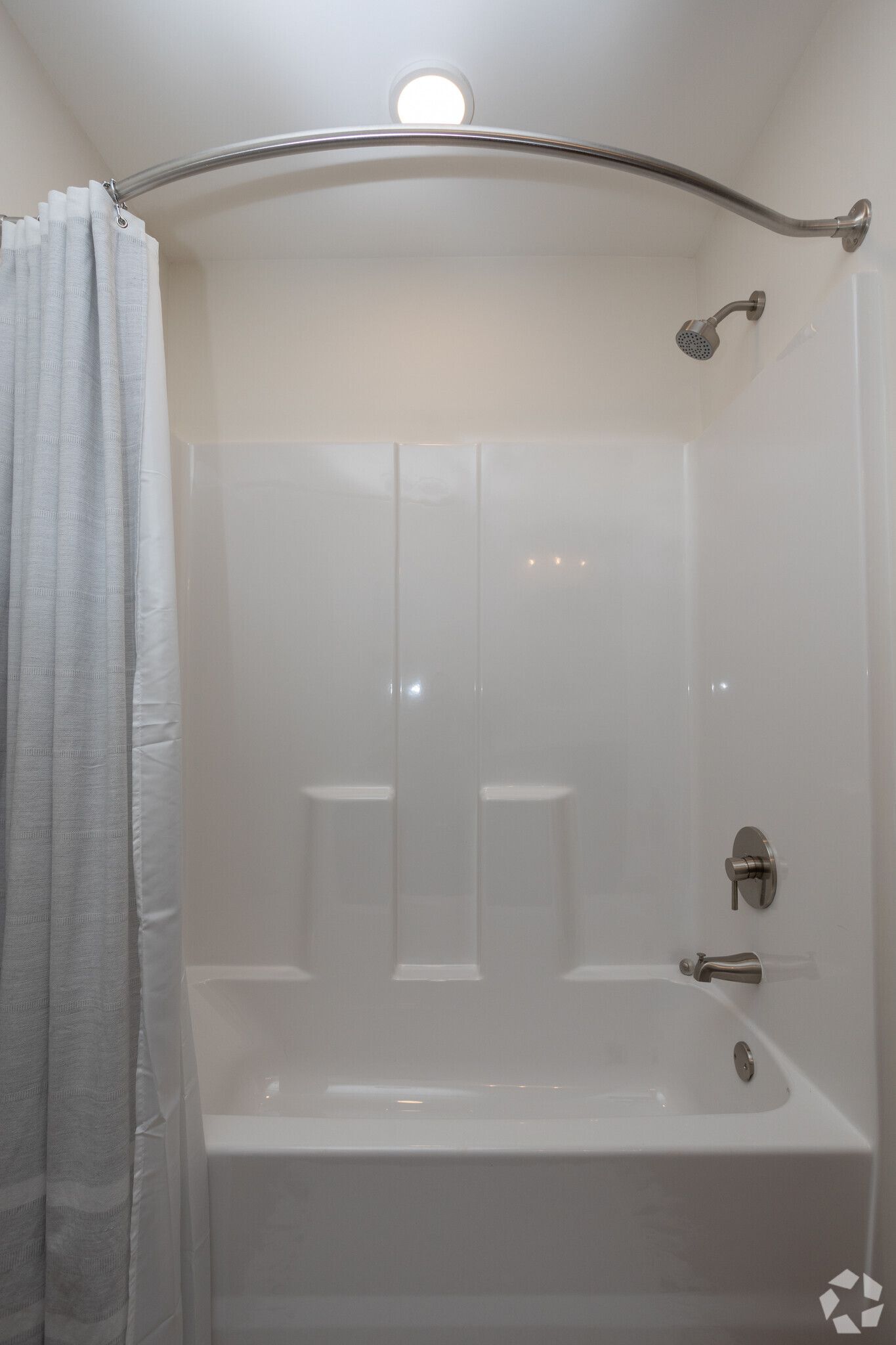 A bathroom with a bathtub and shower curtain.
