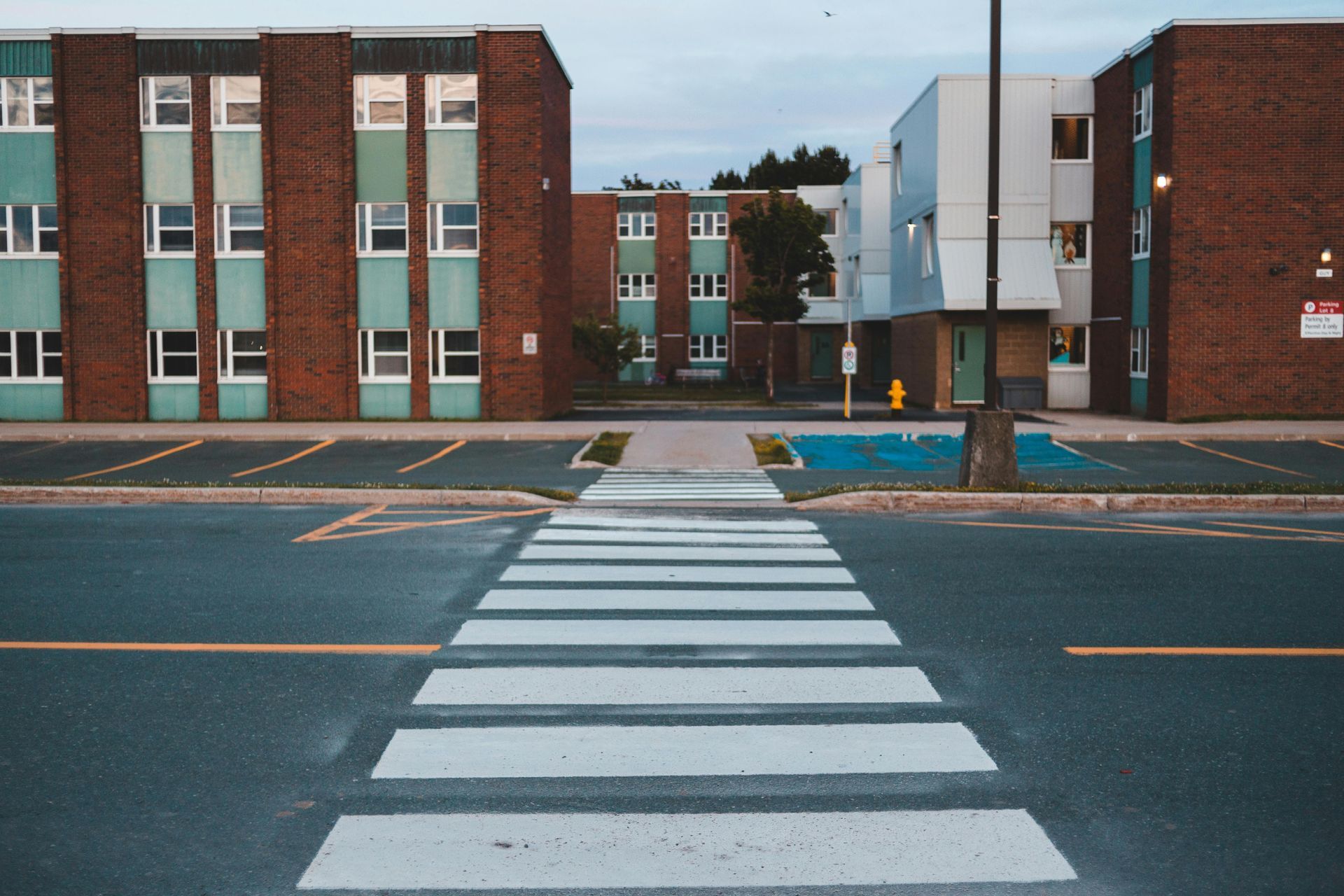 Crosswalk leading to brick apartment buildings on a quiet street
