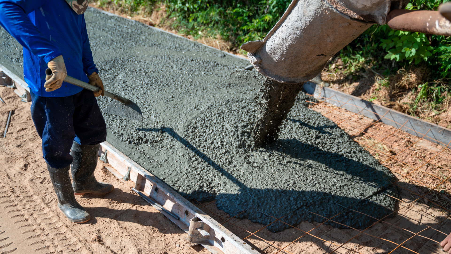 Concrete floor grinder sanding a dusty surface with a green handle and wheels