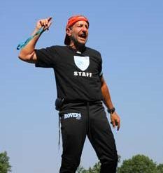 a man wearing a black t-shirt with a shield on it